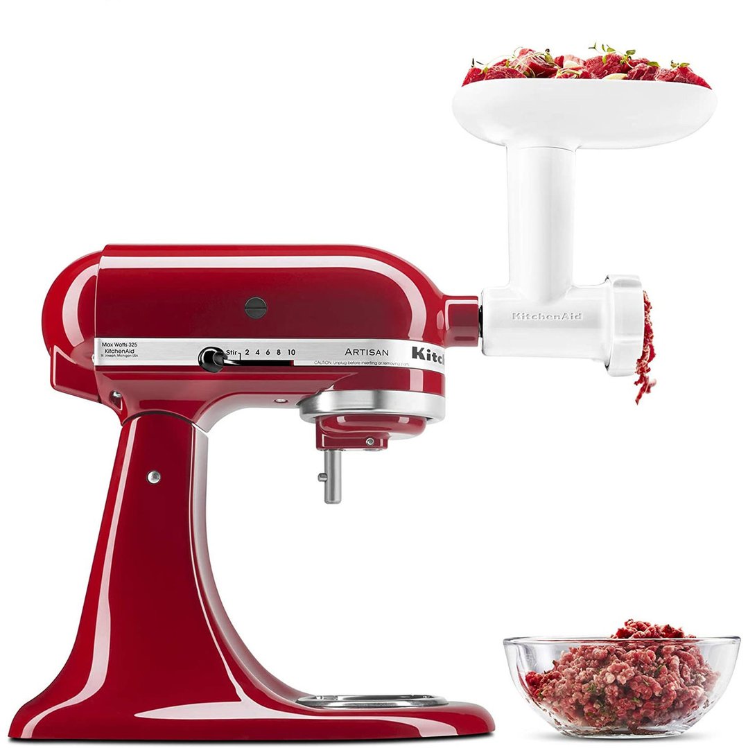 Red stand mixer with food grinder attachment processing meat into a bowl