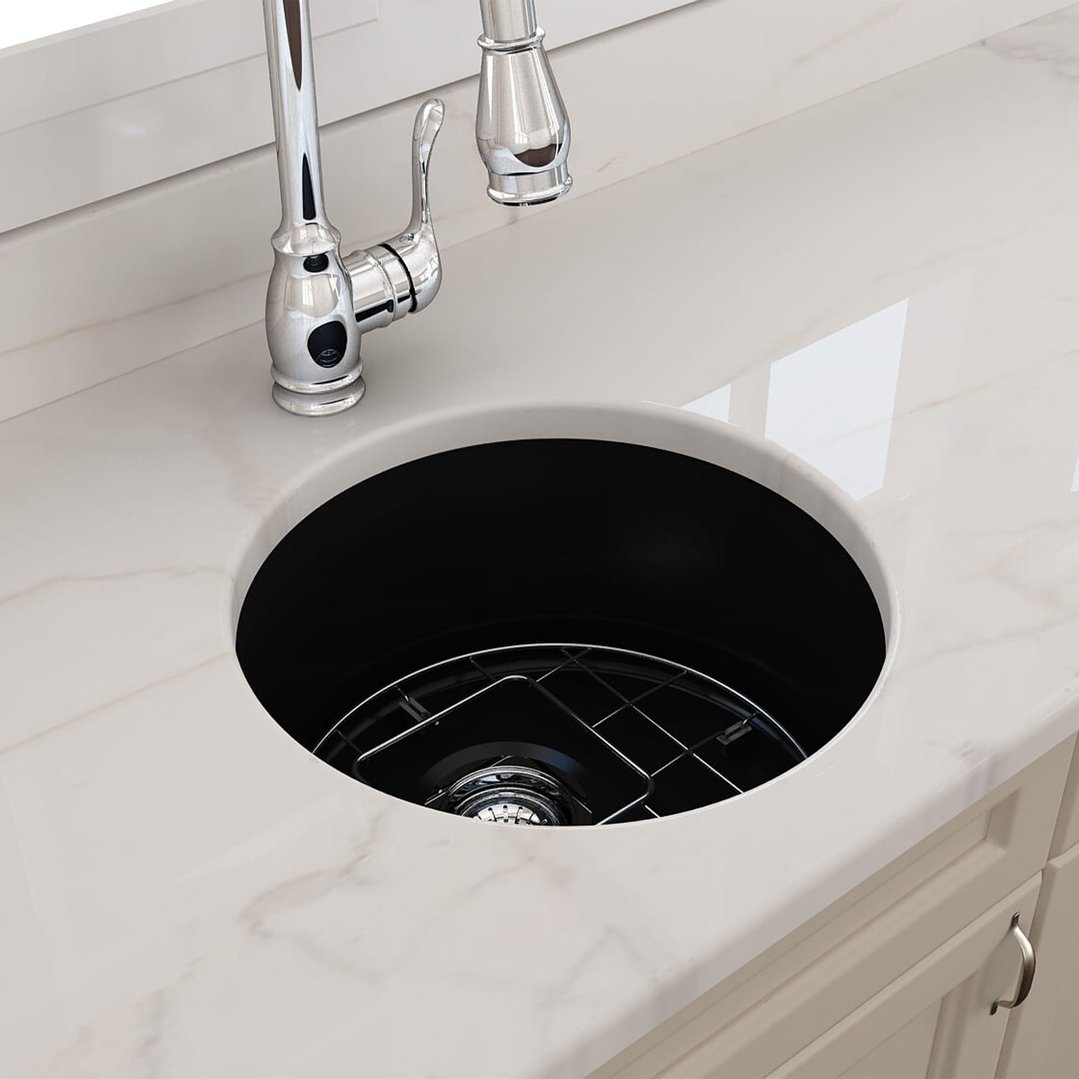 Matte black round sink with chrome faucet in a white marble countertop