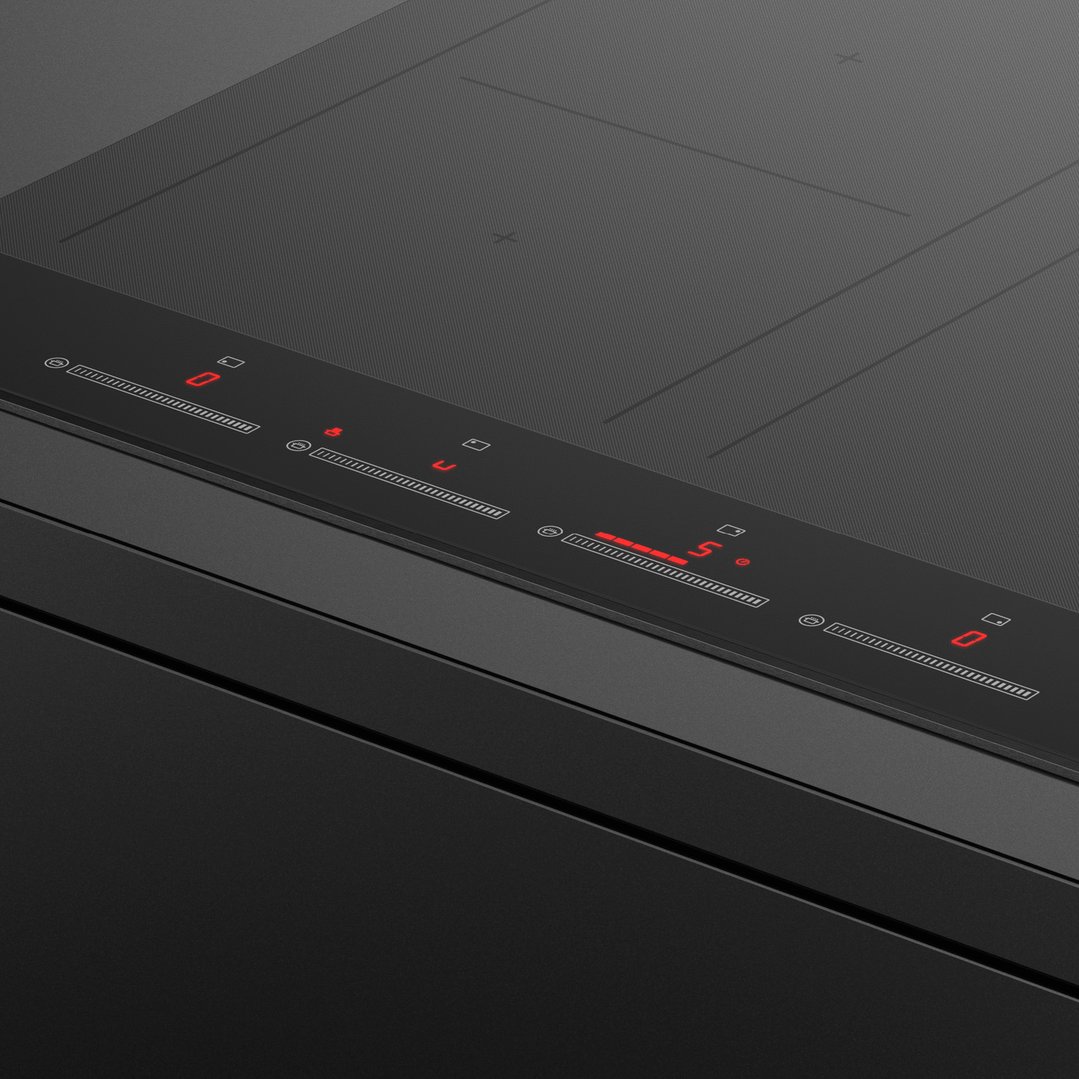 Close-up of a black induction cooktop with red digital controls