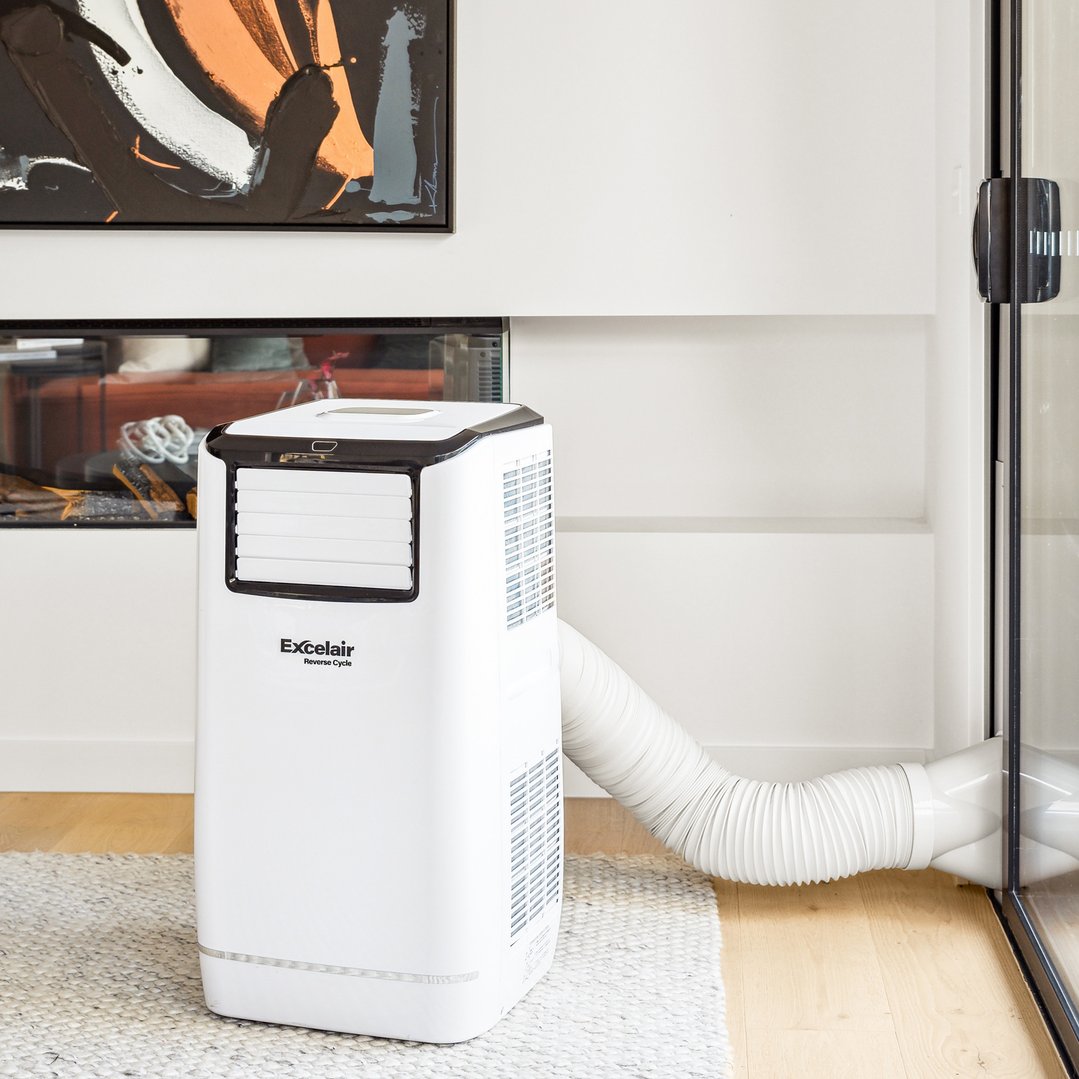 White portable air conditioner with exhaust hose in a living room setting