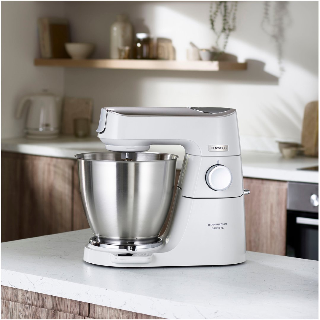 White Kenwood food mixer with a stainless steel bowl on a kitchen counter