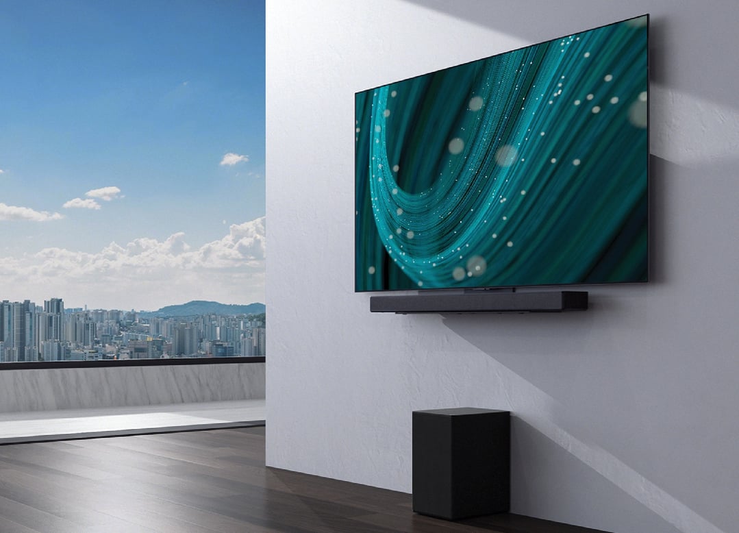 LG C Series Sound Bar and subwoofer in a modern room with a city view