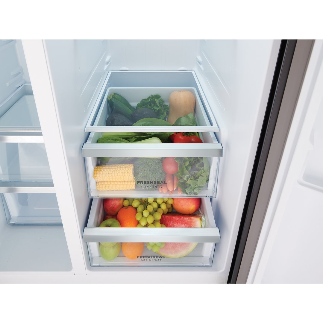 Inside a refrigerator, three crisper drawers filled with fresh fruits and vegetables