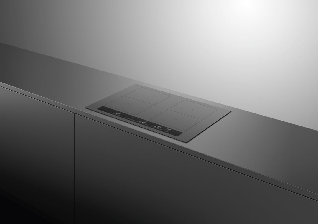 Induction cooktop built into a dark grey kitchen countertop with cabinets below