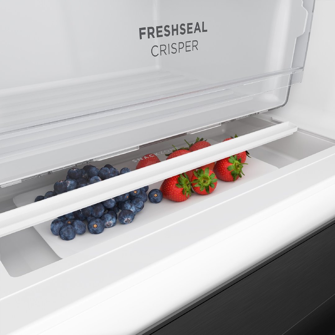 Open fridge crisper drawer with blueberries and strawberries inside