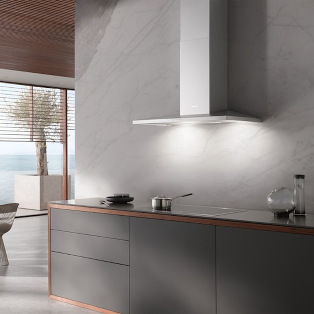Wall-mounted canopy rangehood above a cooktop in a modern kitchen with ocean view