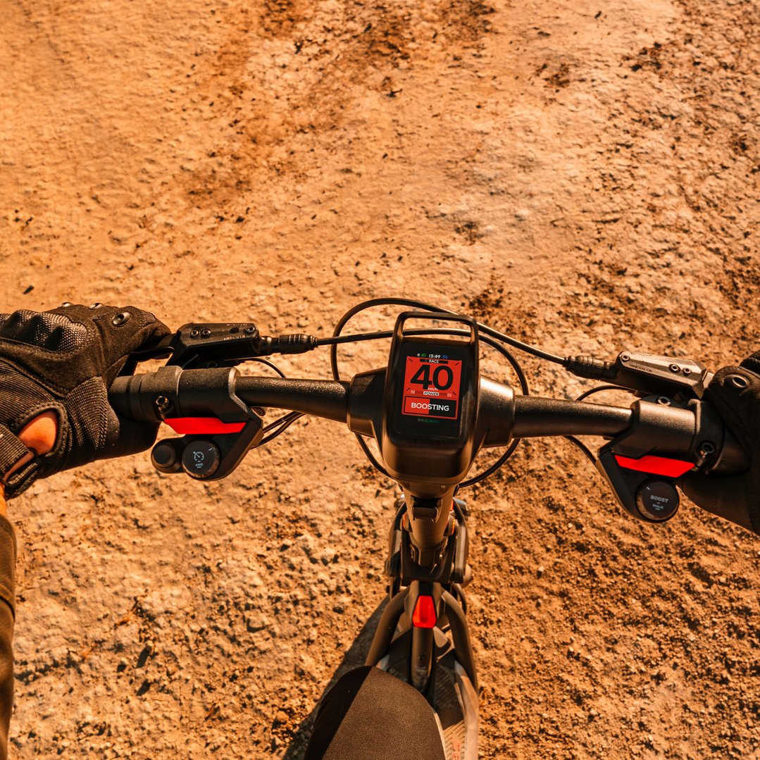 Person riding an electric scooter on a dirt path, view from above