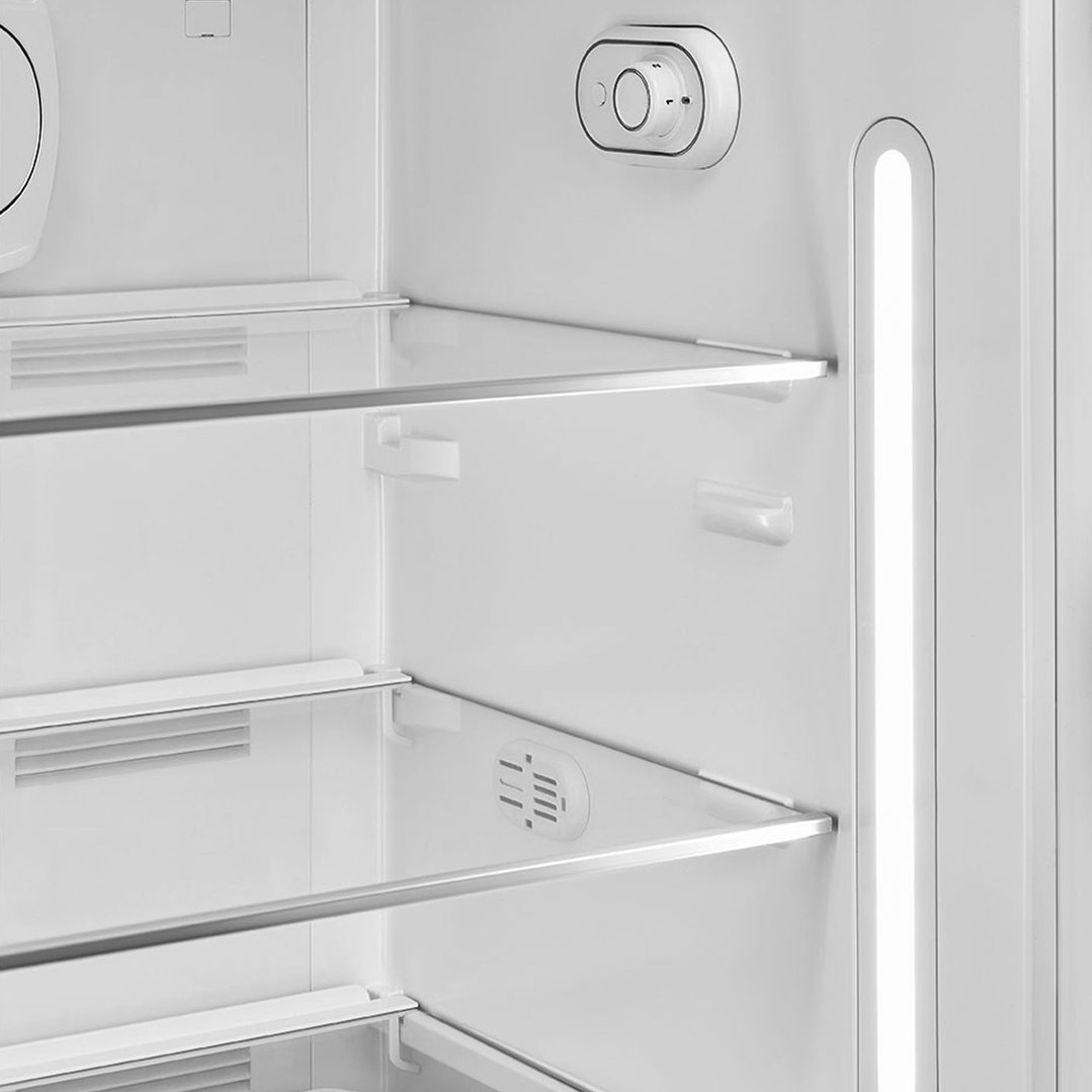 Interior view of a Smeg refrigerator with shelves and temperature control