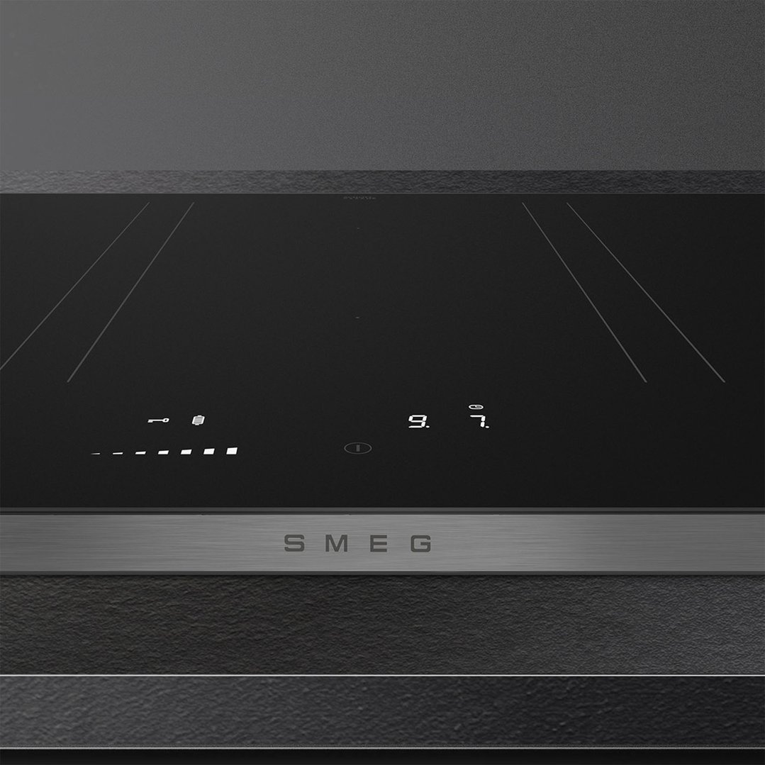 Black induction cooktop with digital controls and a stainless steel trim