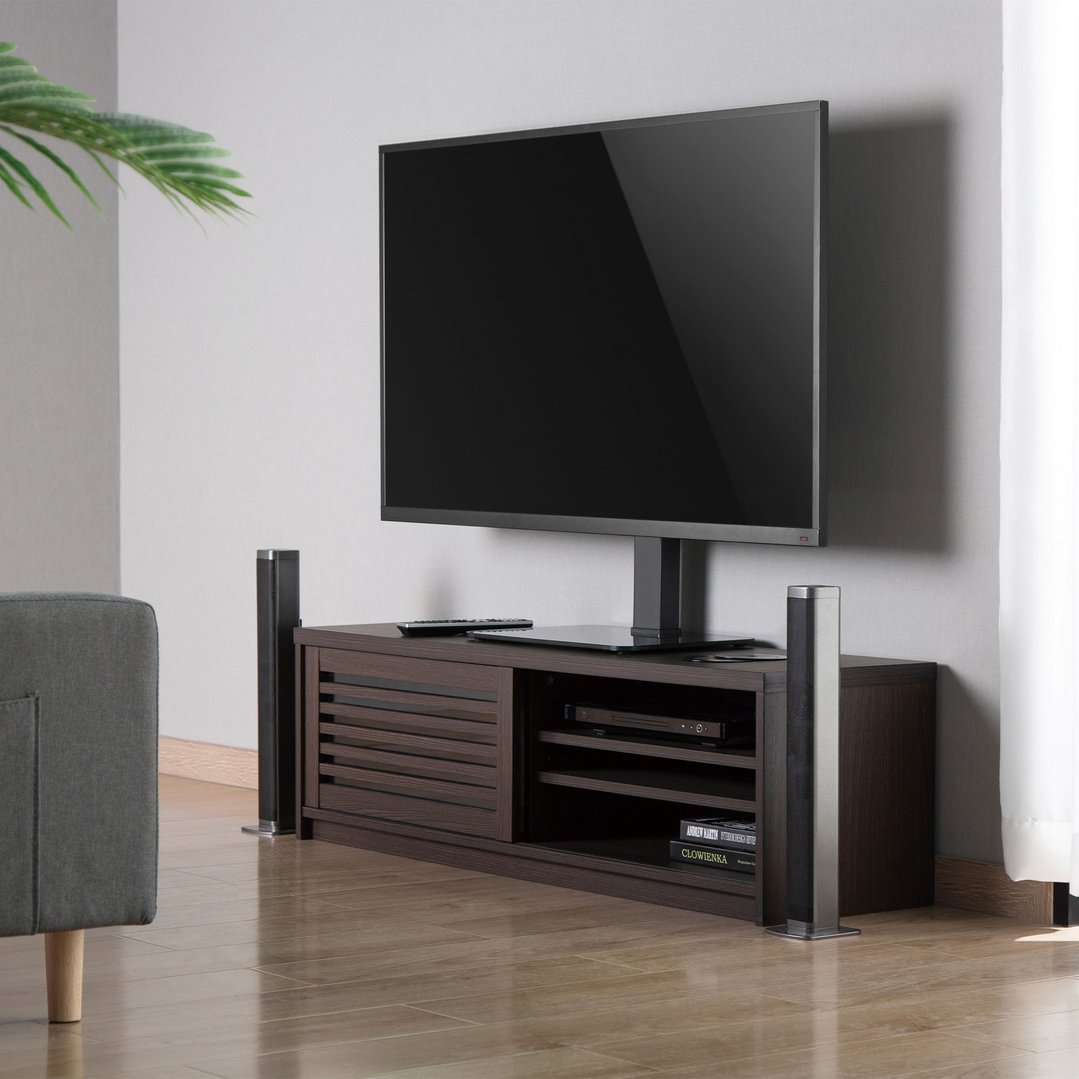 A TV stand with a TV and speakers in a living room setting
