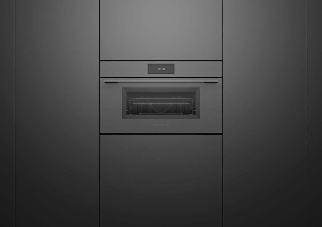A dark grey compact combi-steam oven built into a dark grey kitchen cabinet