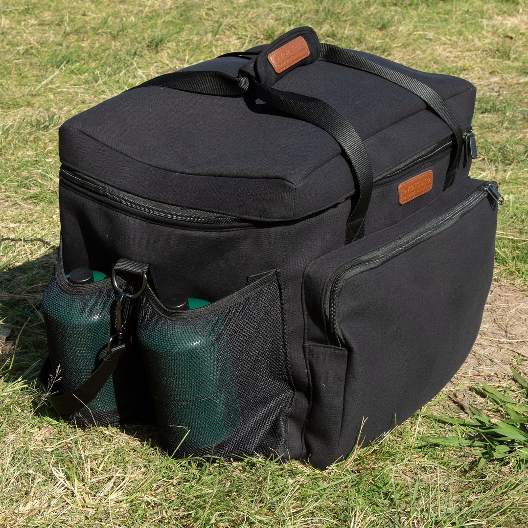Black Everdure Carrier Bag for portable barbeque on green grass outdoors