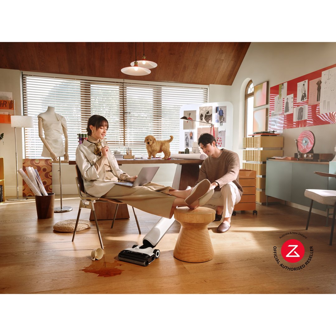Woman using a white Roborock vacuum cleaner to clean a spill on a wooden floor