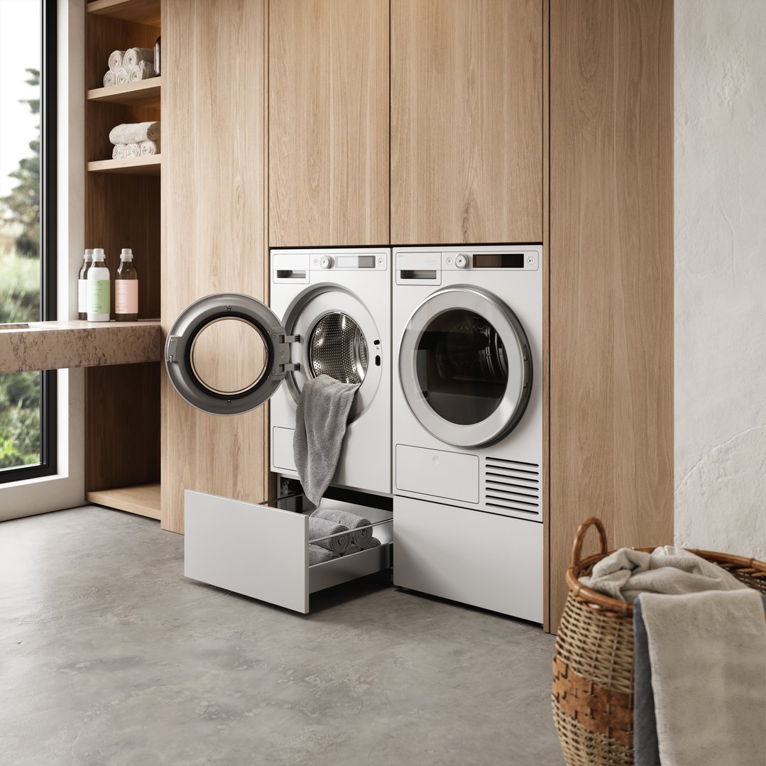 White washer and dryer with an open pull-out drawer in a modern laundry room