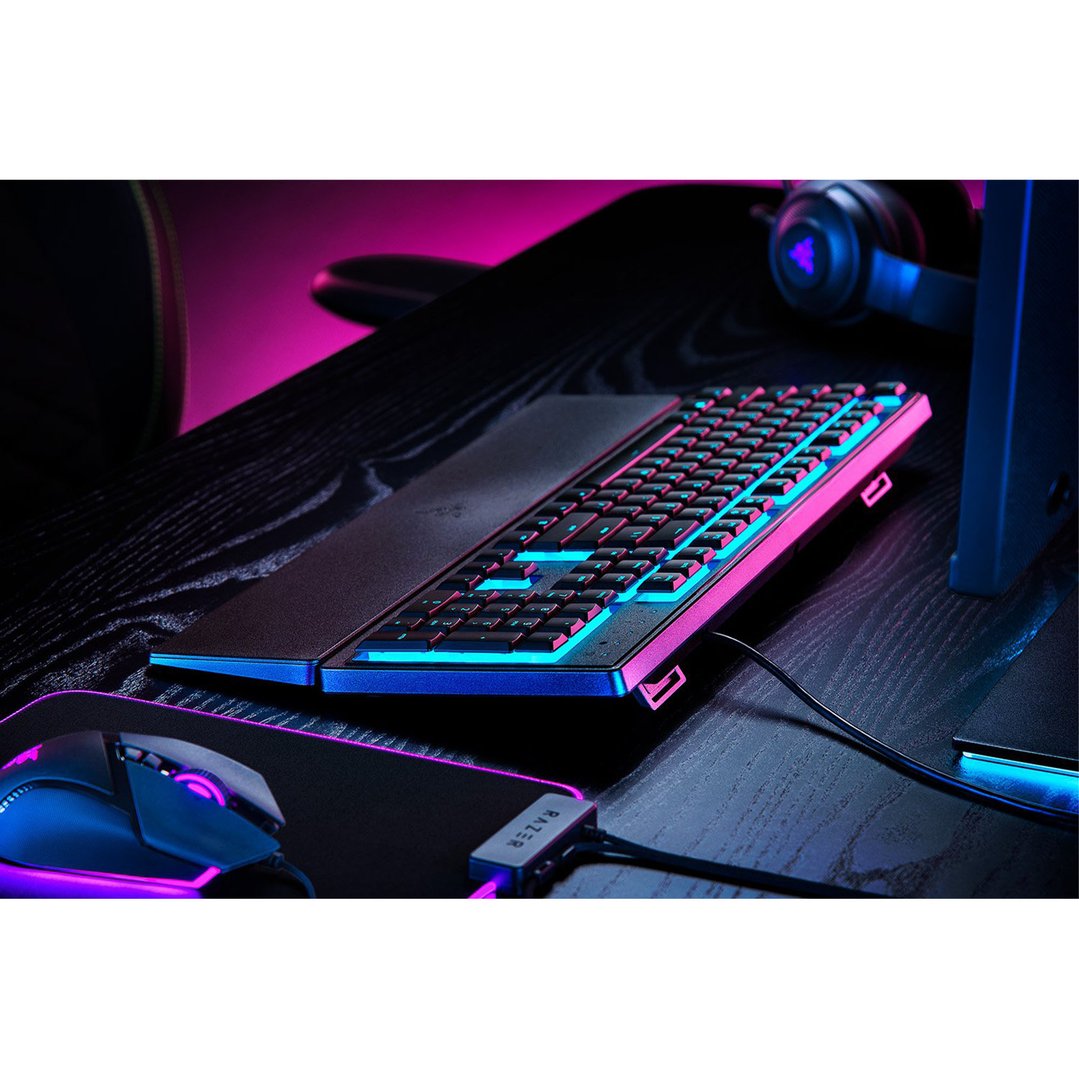 Razer gaming keyboard and mouse on a desk with pink and blue lighting