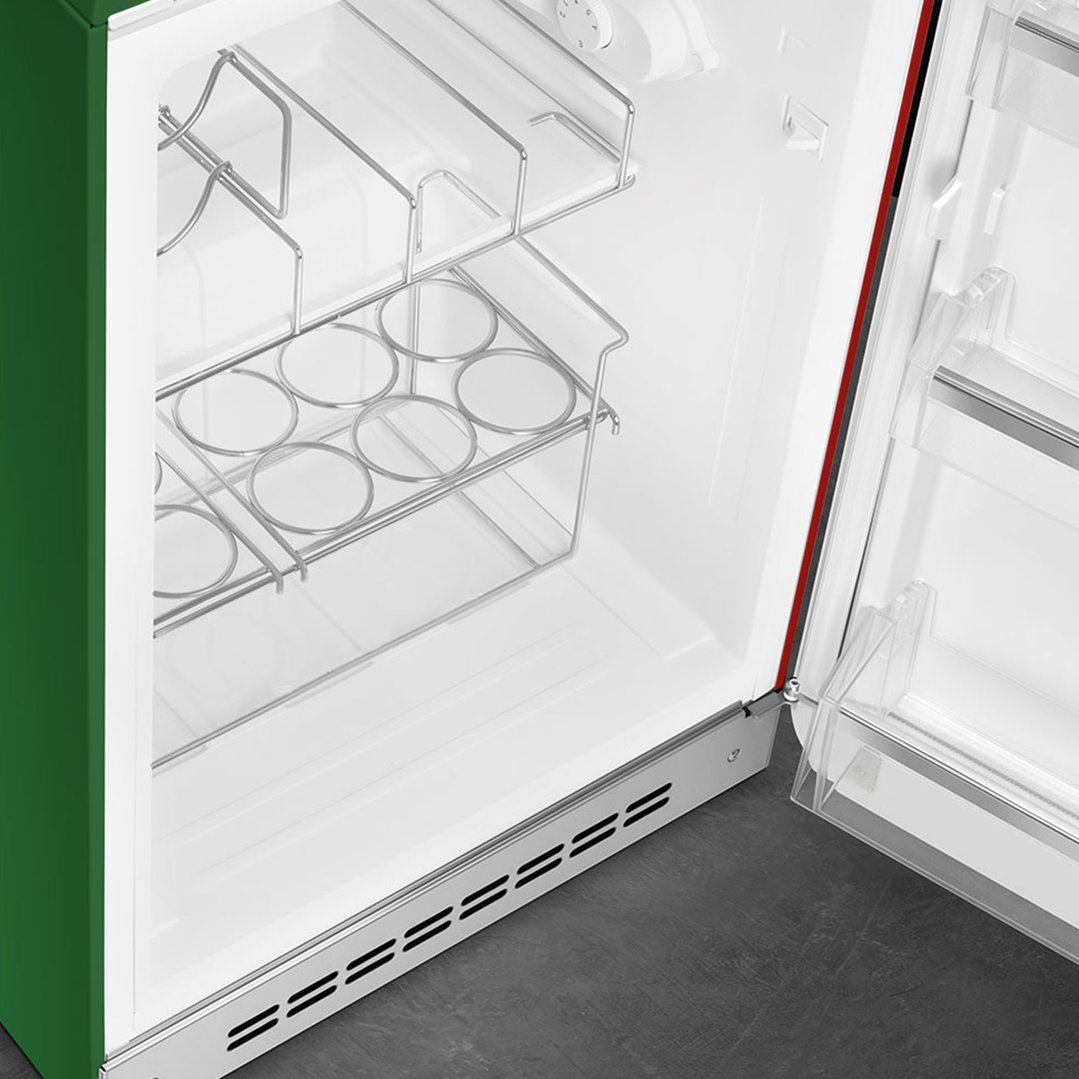 Interior view of a green refrigerator with shelves and a bottle rack
