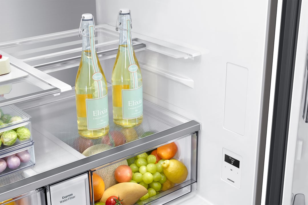 Open refrigerator interior with bottles, fruits, and vegetables on shelves and in drawers