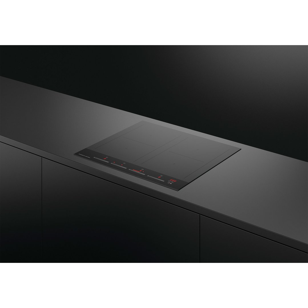 Black induction cooktop with red digital display built into a dark kitchen counter