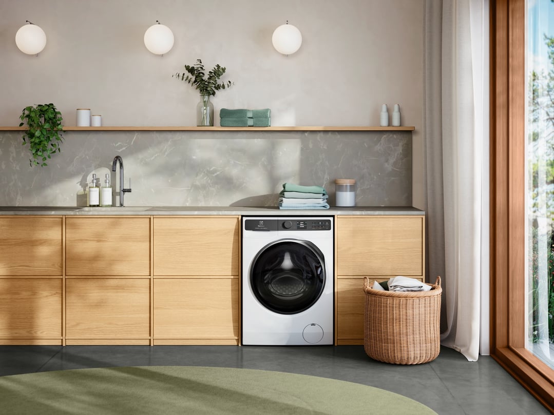 White washer dryer combo built into wooden cabinetry in a modern laundry room