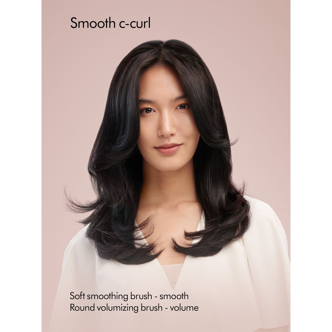 Woman with smooth c-curl hair styled by the Dyson Airwrap multi-styler
