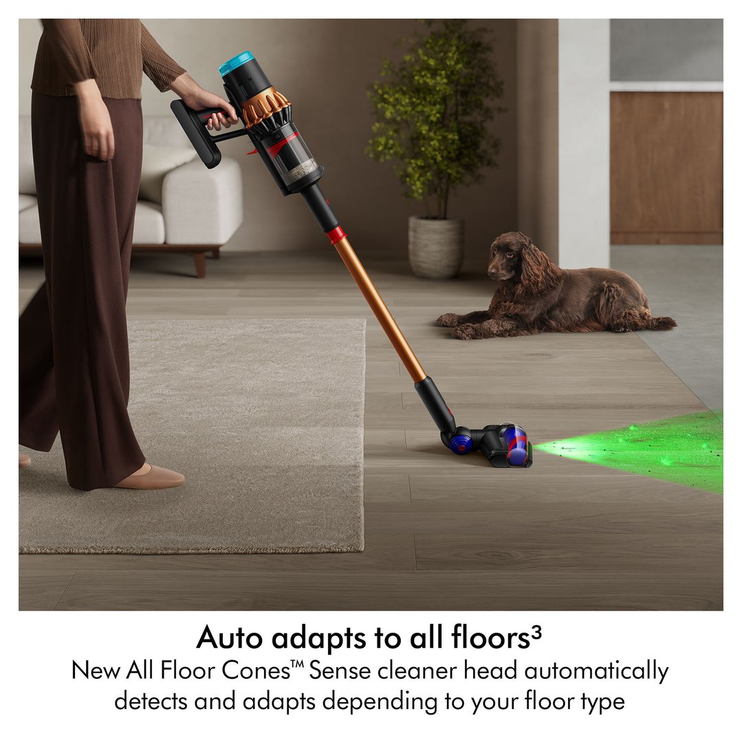 Woman vacuuming a wooden floor with a Dyson handstick vacuum, dog nearby