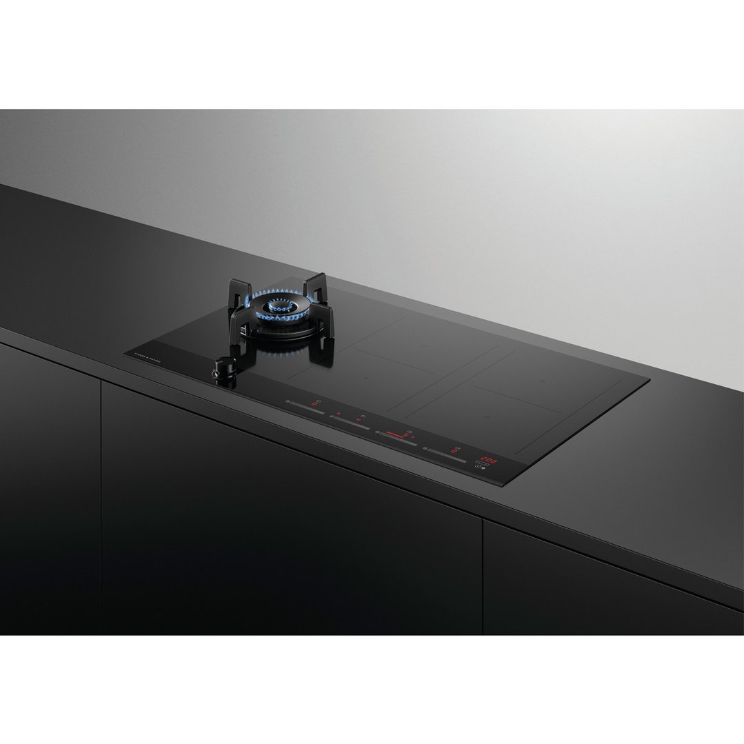 Black hybrid cooktop with gas burner and induction zones in a modern kitchen