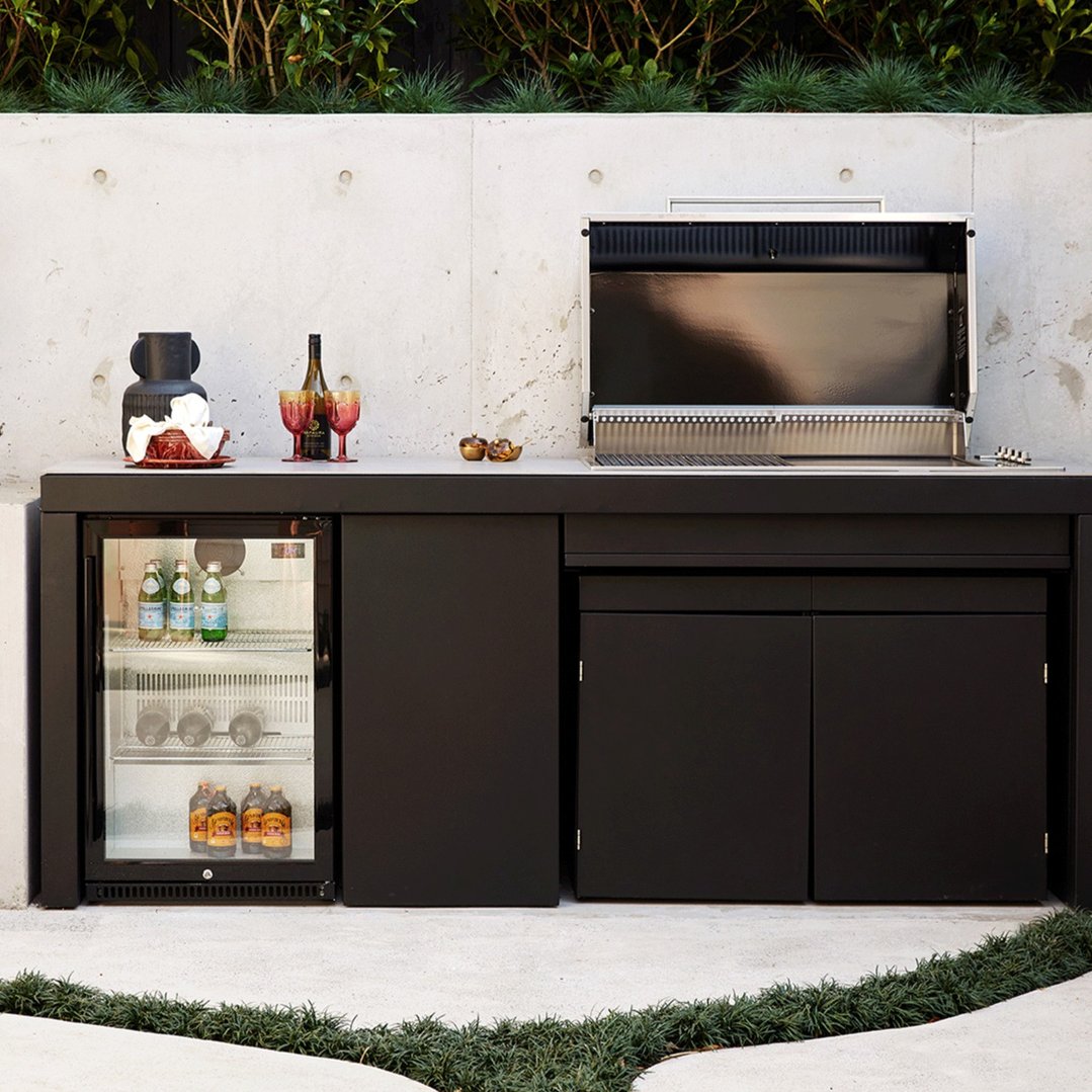 Outdoor beverage centre and grill built into a concrete and black cabinet
