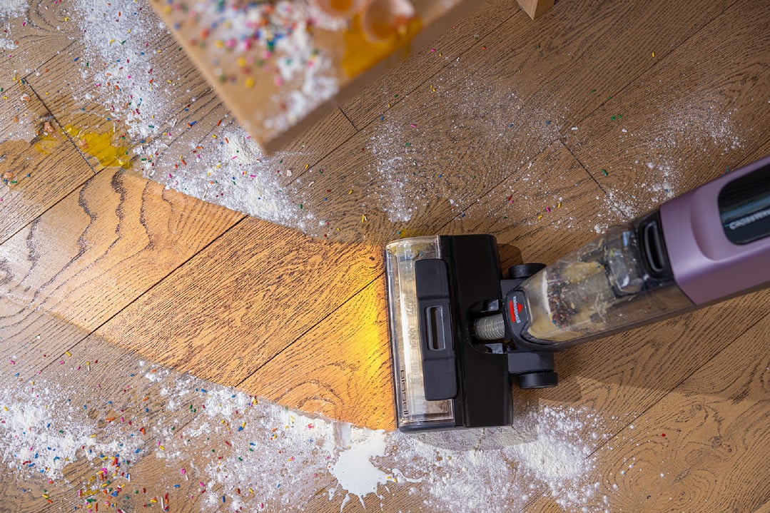 Top-down view of a BISSELL handStickVacuum cleaning up a messy floor