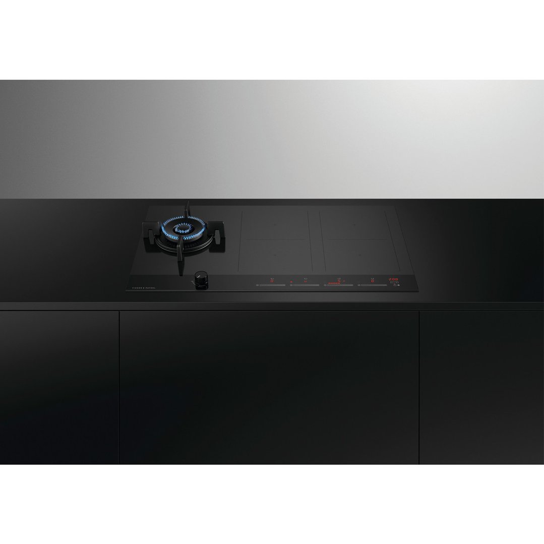 Hybrid cooktop with gas burner and induction zones in a modern black kitchen