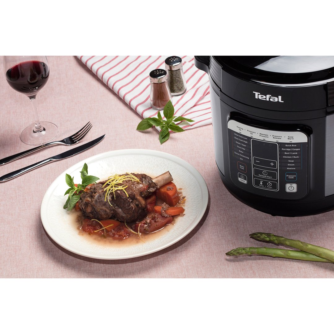 Tefal Home Chef Smart Multicooker on a table with a meal and wine