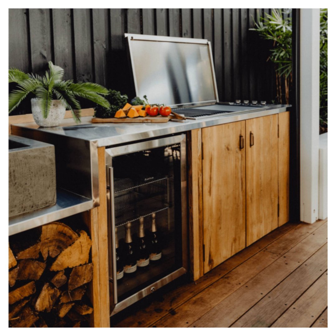 Outdoor beverage chiller built into a wooden outdoor kitchen with a grill