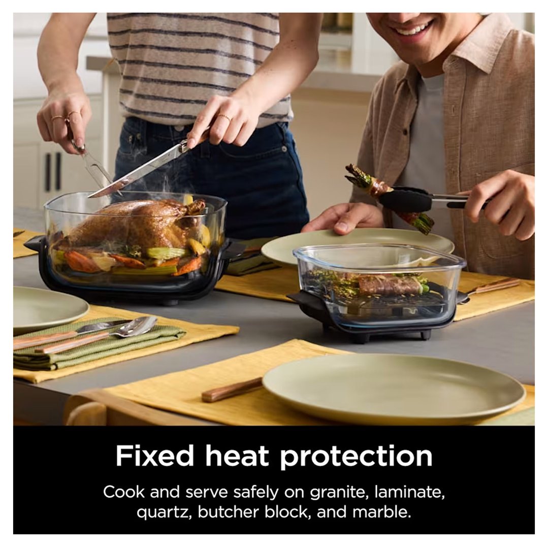 Two people serving food from two Ninja air fryers on a dining table