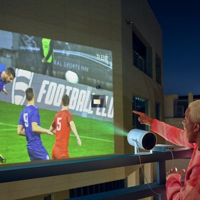 A man watching the soccer through a projector